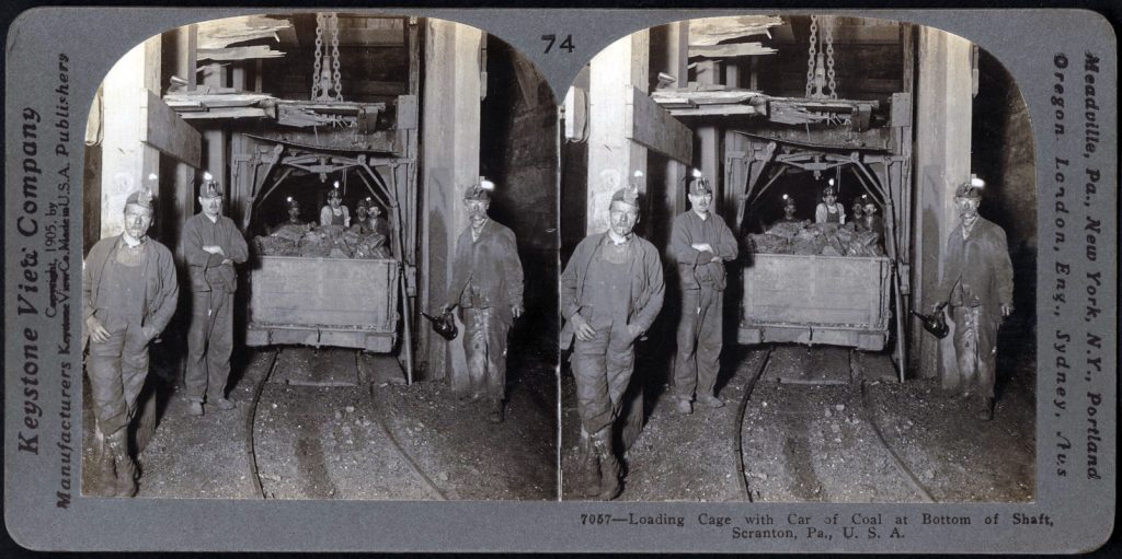 Fotografía estéreo de la jaula en el fondo del pozo cargada con un vagón con carbón. Scranton, Pensilvania. Estados Unidos. 1909.