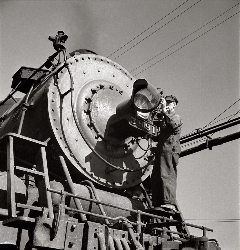 Limpiando el faro de la locomotora en el patio de Atchison, Topeka y Santa Fe. Needles, California. EEUU. 1943