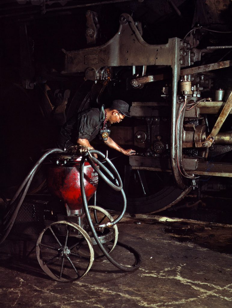 Thomas Madrigal engrasando una locomotora en la casa de máquinas, ferrocarril de Rock Island, Illinois. EEUU. 1943