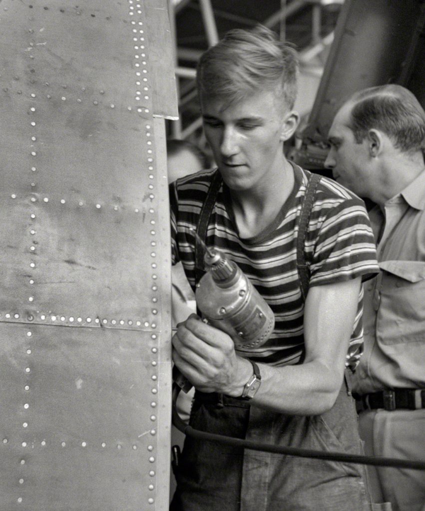 Trabajador de Vultee Aircraft Co. usando un taladro eléctrico en un fuselaje. Nashville. EEUU. 1942